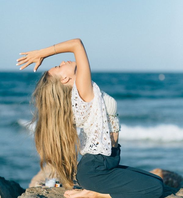 Young woman in a calm seated yoga pose at sunrise.